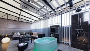 A modern indoor space with a large jacuzzi, a flat-screen TV, and a shower area. - Hotel Plant -garden Resort- Adult Only (Toyokawa)