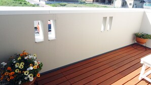 A wooden deck with a potted plant and a flower arrangement. - Family Lodge Hatagoya Kisarazu Kaneda (Kisarazu)
