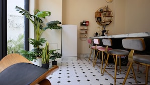 A modern kitchen with a marble countertop, a refrigerator, and a potted plant. - Yes Yes I am Willing (Tainan)