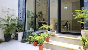 A modern building with large glass windows, potted plants, and a visible interior with furniture. - Yes Yes I am Willing (Tainan)