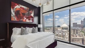 A modern hotel room with a large bed, a city view, and a large abstract painting on the wall. - Vue Spectaculaire Penthouse (Atlanta)