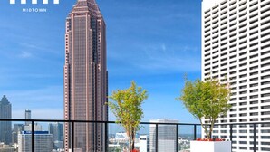 A rooftop pool with a city skyline view, including a prominent skyscraper.
