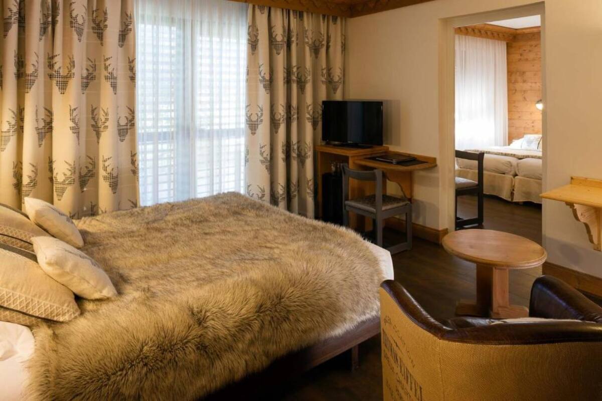 Une chambre d’hôtel avec un grand lit, une télévision, un bureau et une petite table.