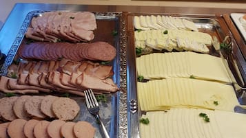 Un buffet proposant une variété de viandes et de fromages.