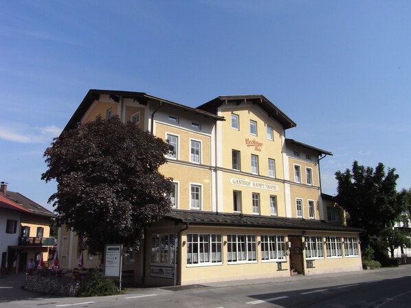 A two-story building with a sign reading "Wochinger Brau" and "GASTHOF KAMPENWAND". - Gasthof Kampenwand Aschau (Aschau im Chiemgau)