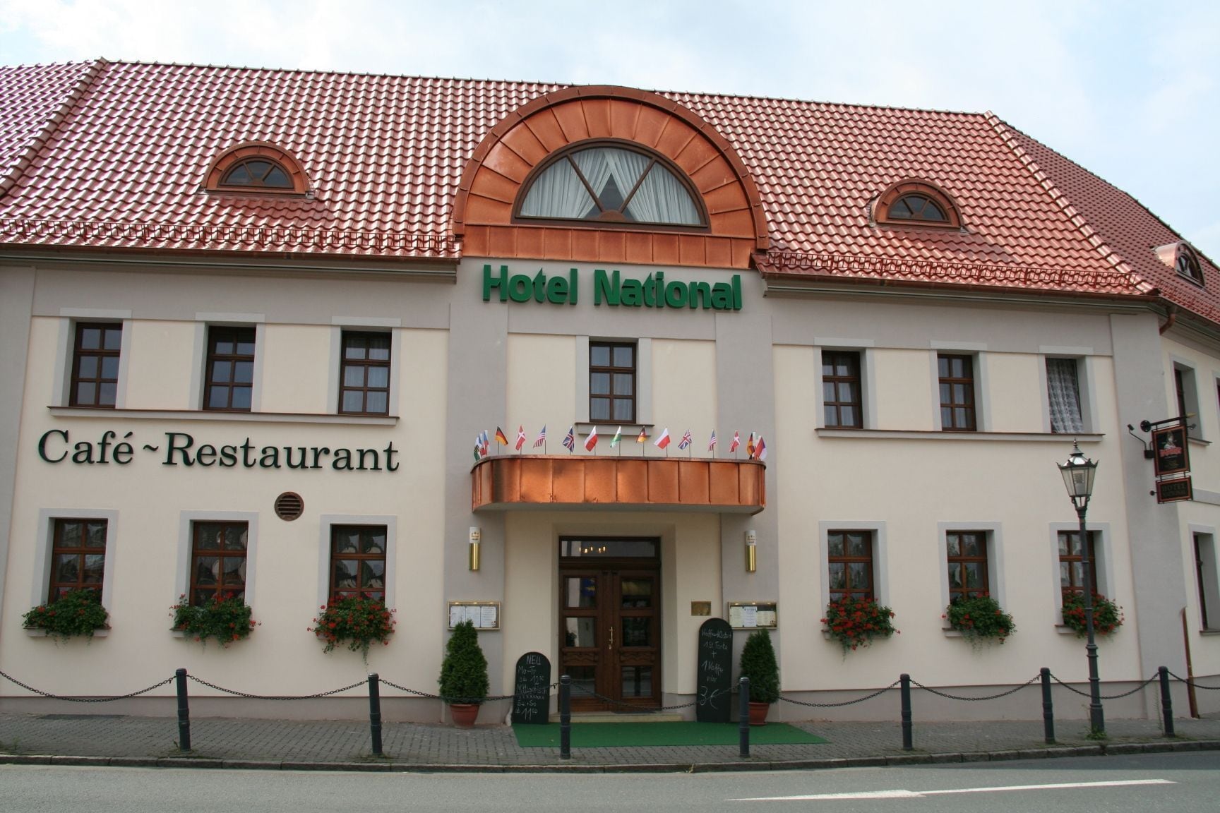 A building with a sign reading "Hotel National" and "Café-Restaurant" indicating it is a hotel with a dining area.