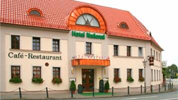 A building with a Café-Restaurant sign and a Hotel National sign.