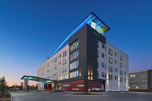 A modern hotel with a flat roof, multiple floors, and a prominent entrance with a covered walkway. - Aloft by Marriott Waco Downtown (Waco)