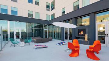 A modern outdoor lounge area with seating and a fireplace.