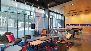 A modern lounge area with seating, a coffee table, and a bar area with a neon sign.
