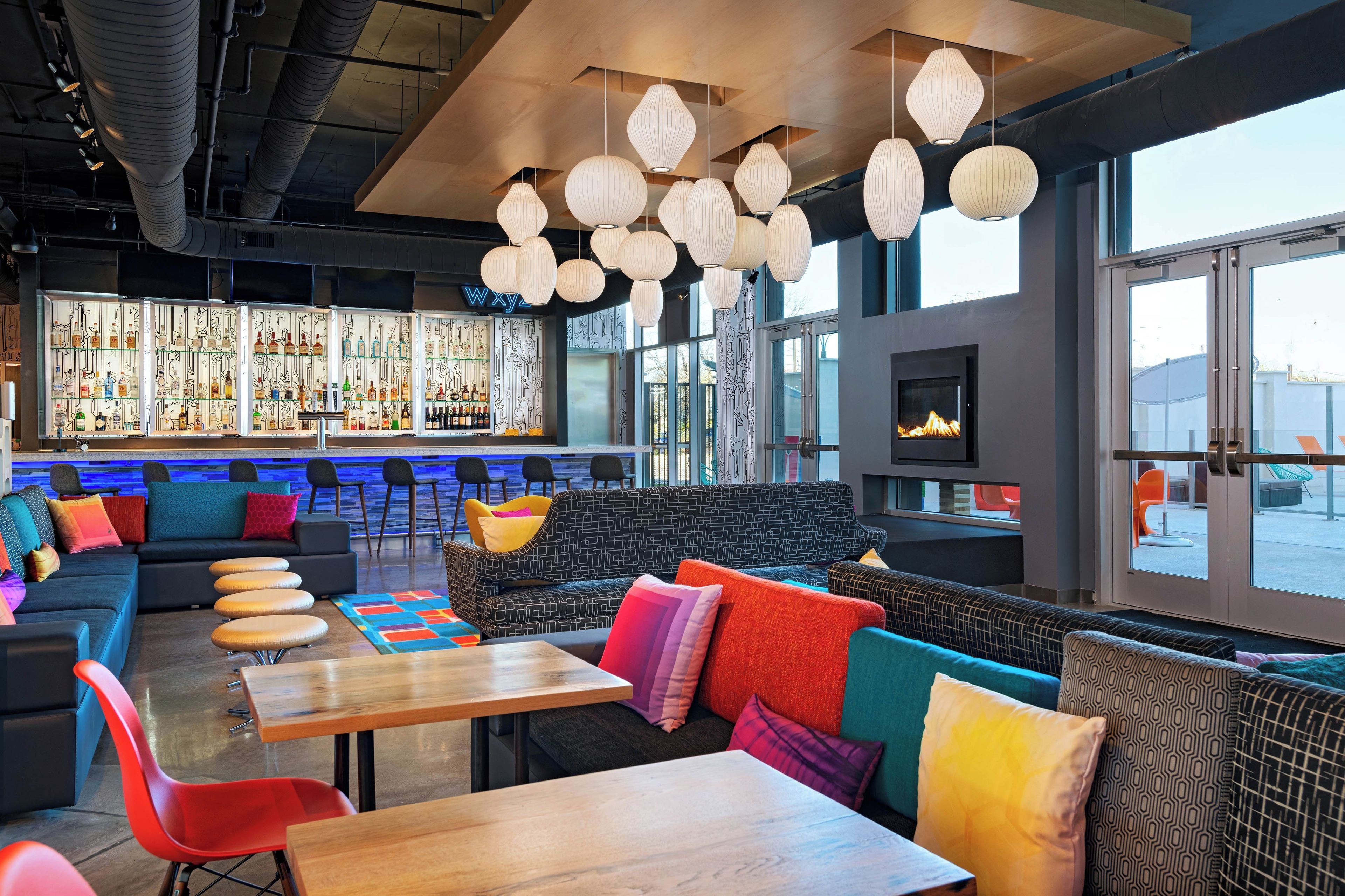 A modern bar area with seating, a bar counter, and a fireplace.
