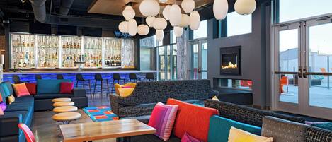 A modern bar area with seating, a bar counter, and a fireplace.