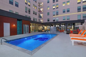 Una piscina al aire libre, sillones reclinables de piscina