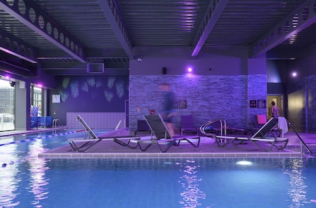 Una piscina techada, sillones reclinables de piscina