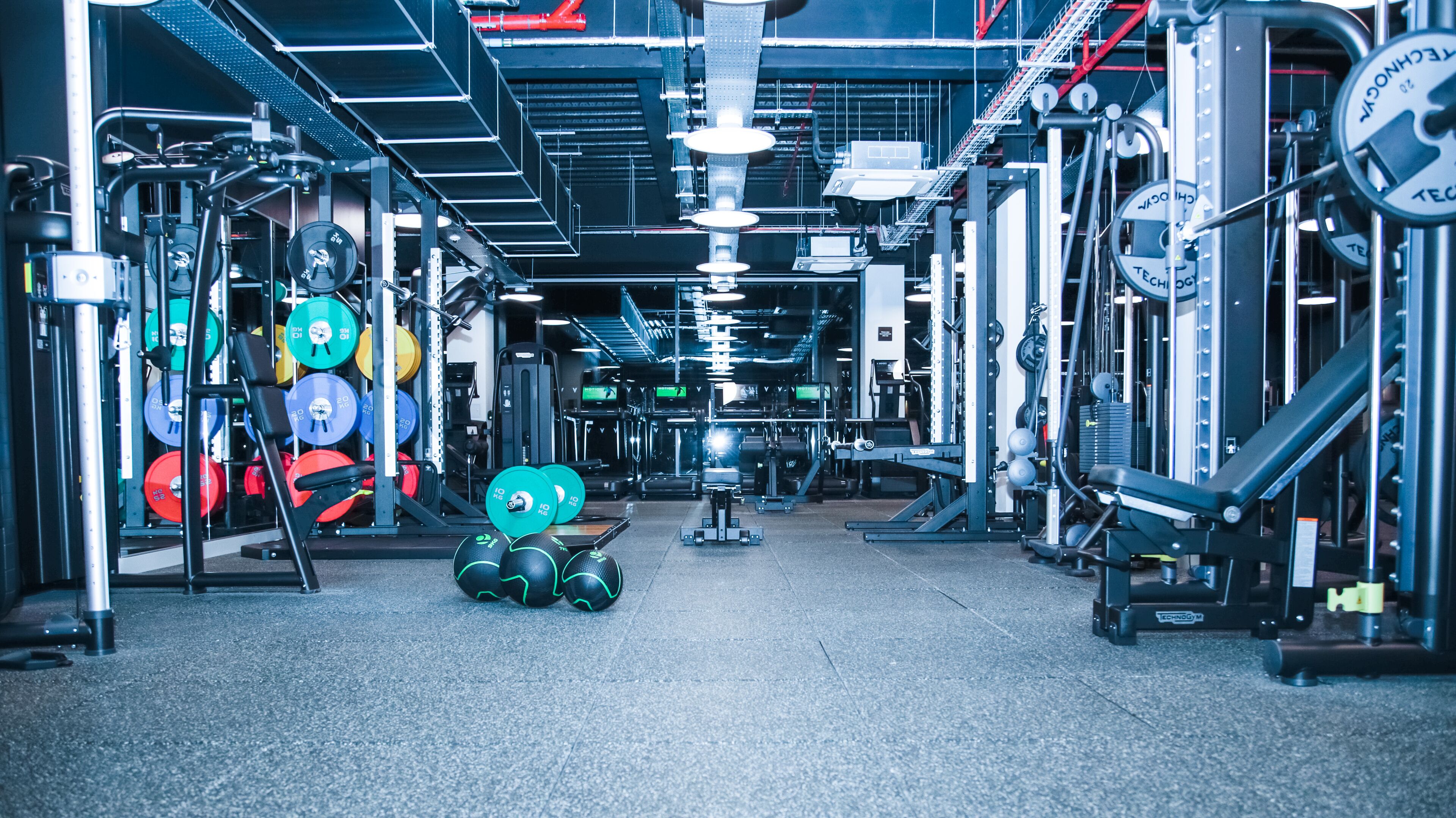 A gym with various weightlifting equipment, including barbells and weight plates.