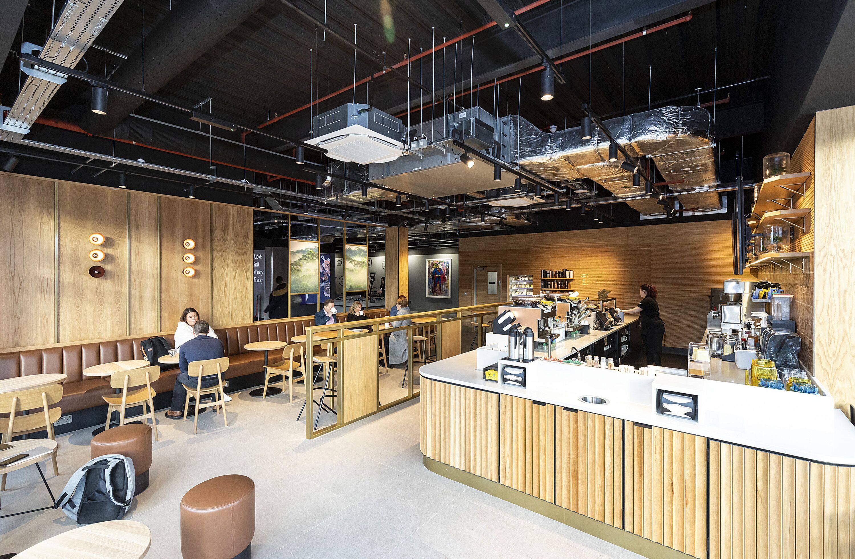 A modern cafe with wooden booths, a bar area, and a counter with various items.