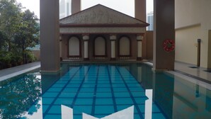 An indoor swimming pool with a classical architectural design, featuring columns and a central pediment. - Maytower Apartment (Kuala Lumpur)