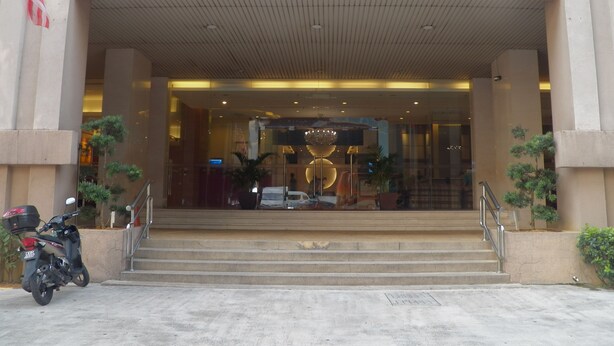 The May Tower Hotel & Serviced Apartments entrance with a clear view of the steps leading up to the entrance, a parked scooter, and a flag. - Maytower Apartment (Kuala Lumpur)