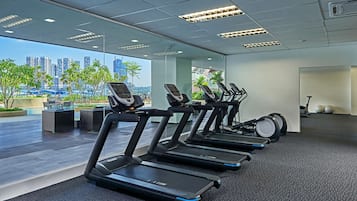 A modern gym with treadmills, a rowing machine, and exercise balls.