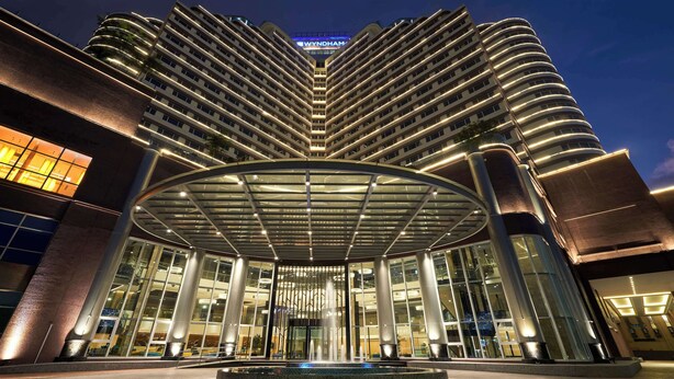 Un hotel moderno con una fachada curva distintiva, un atrio central y una entrada destacada.