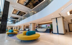 A spacious lobby with a reception desk, seating areas, and a high ceiling with glass railings. - Wyndham Acmar Klang (Klang)