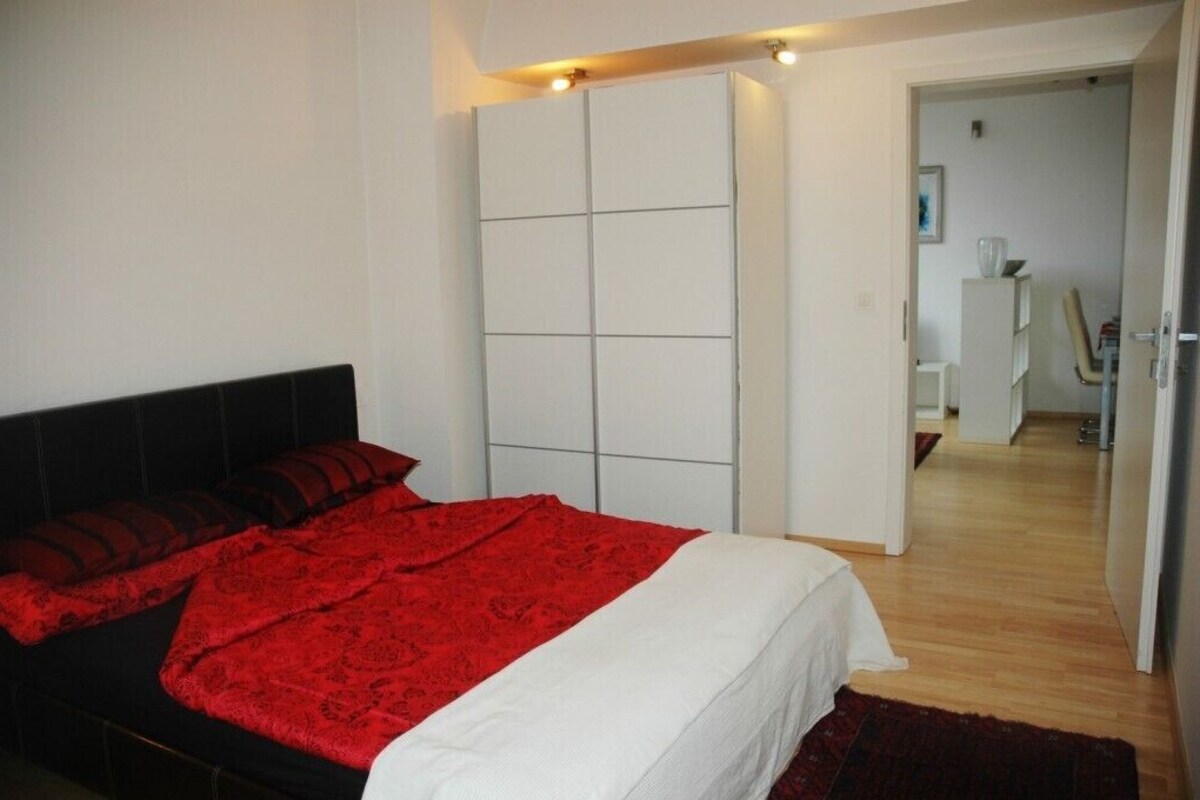 Une chambre à coucher avec un lit, une armoire et un bureau.