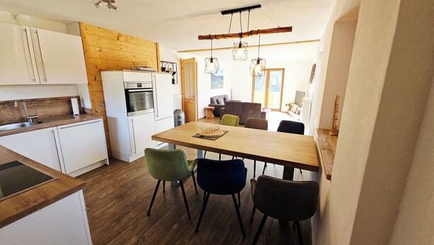 A compact kitchen with white cabinets, a built-in oven, and a wooden countertop. - Arrive and feel good in the exclusive and modern Chalet Weitsee (Reit im Winkl)