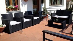 Un patio con muebles de mimbre, incluyendo dos sofás y una mesita de centro.