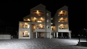 A multi-story hotel with a central courtyard, balconies on each floor, and outdoor seating areas. - Buyeo Park Art Villas (Buyeo)
