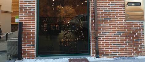 A brick building with a green awning labeled "Sharp's Flat" and a sign indicating it offers coffee and food.