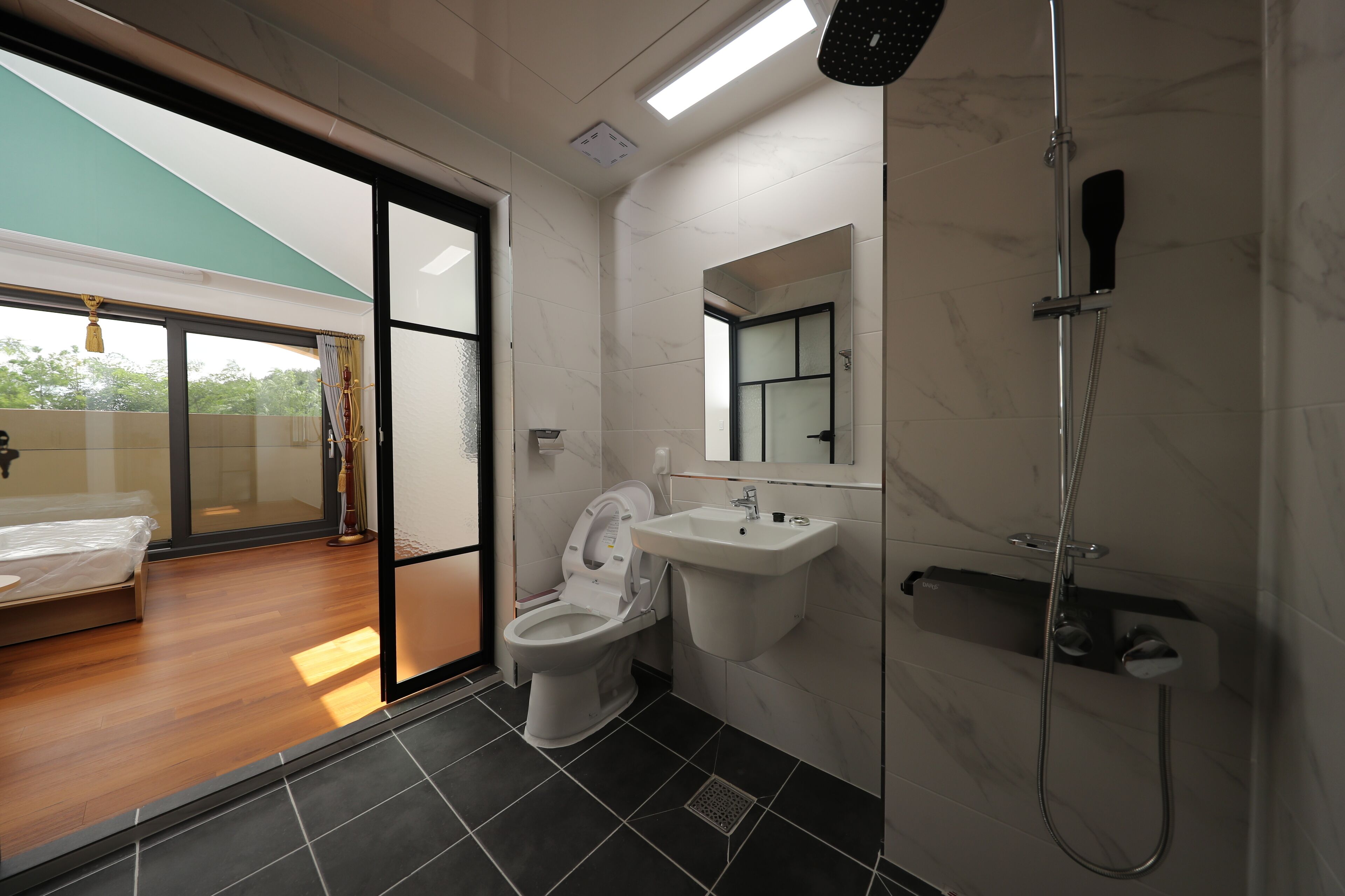 Et moderne badeværelse med toilet, vask og bruser.