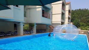 A swimming pool with clear blue water, lounge chairs, and a large transparent ball. - Buyeo Park Art Villas (Buyeo)