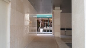 A corridor with tiled walls and a ceiling with recessed lighting. - Buyeo Park Art Villas (Buyeo)