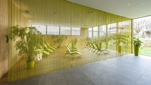 Un intérieur moderne avec un mur en bambou, un coin salon et de grandes fenêtres.