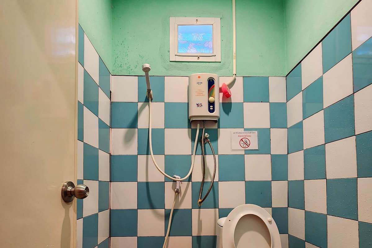 Un baño pequeño con inodoro, ducha y lavabo.