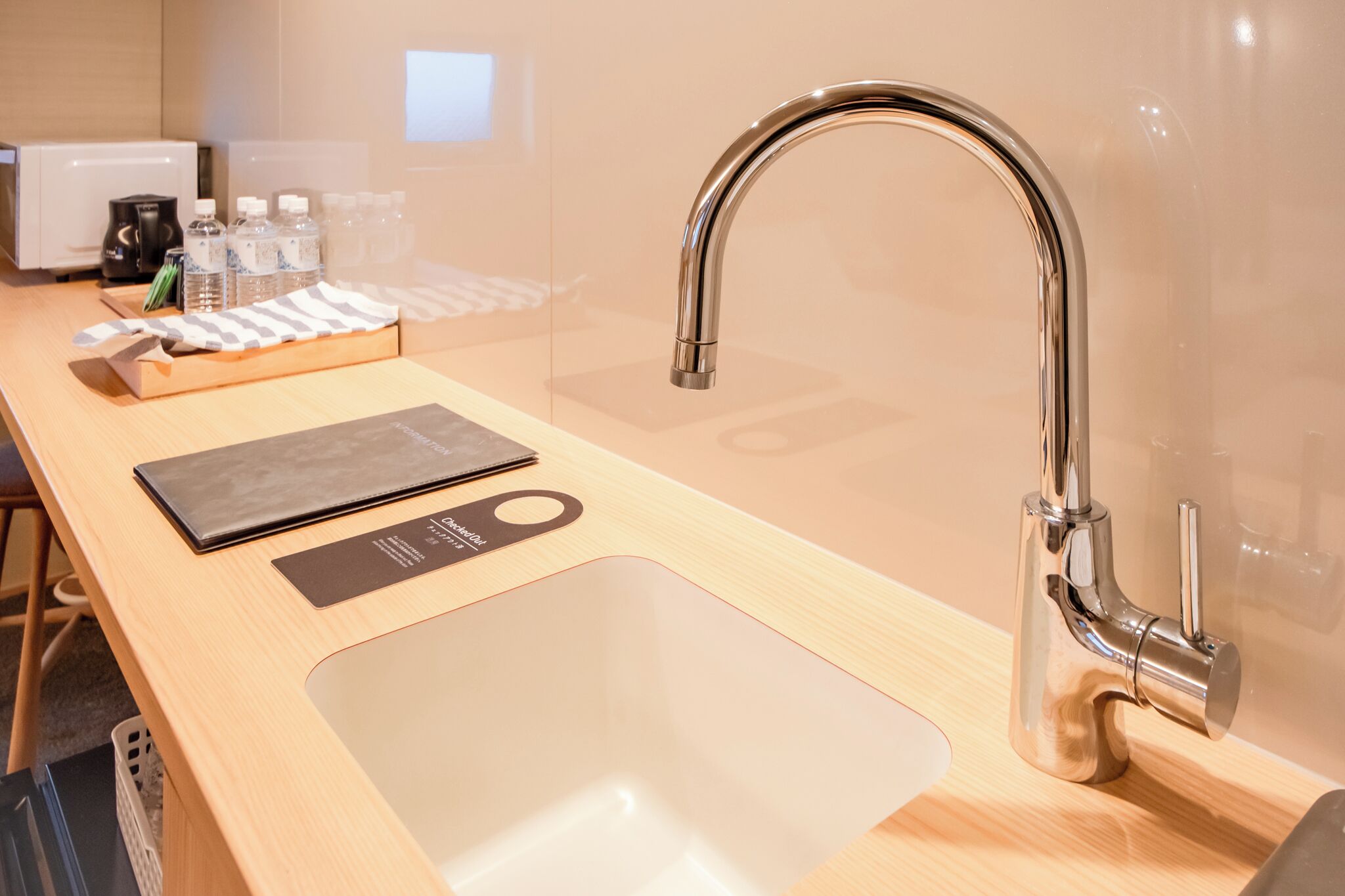 Une cuisine moderne équipée d’un évier en acier inoxydable, d’un four à micro-ondes et d’un distributeur d’eau.