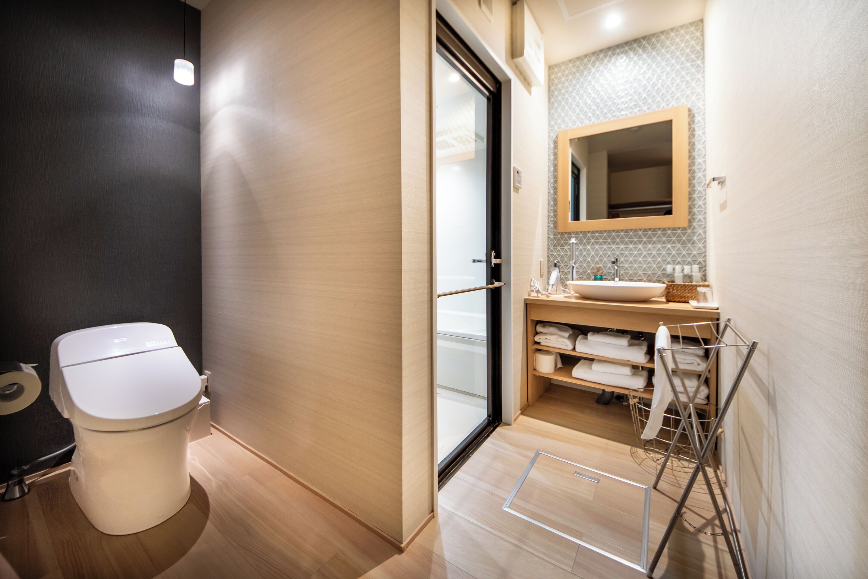 A modern bathroom with a toilet, sink, and towel rack.