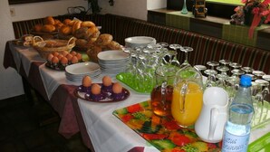 A buffet table with various food items, plates, and glasses. - Tannenhof (Erlenbach am Main)