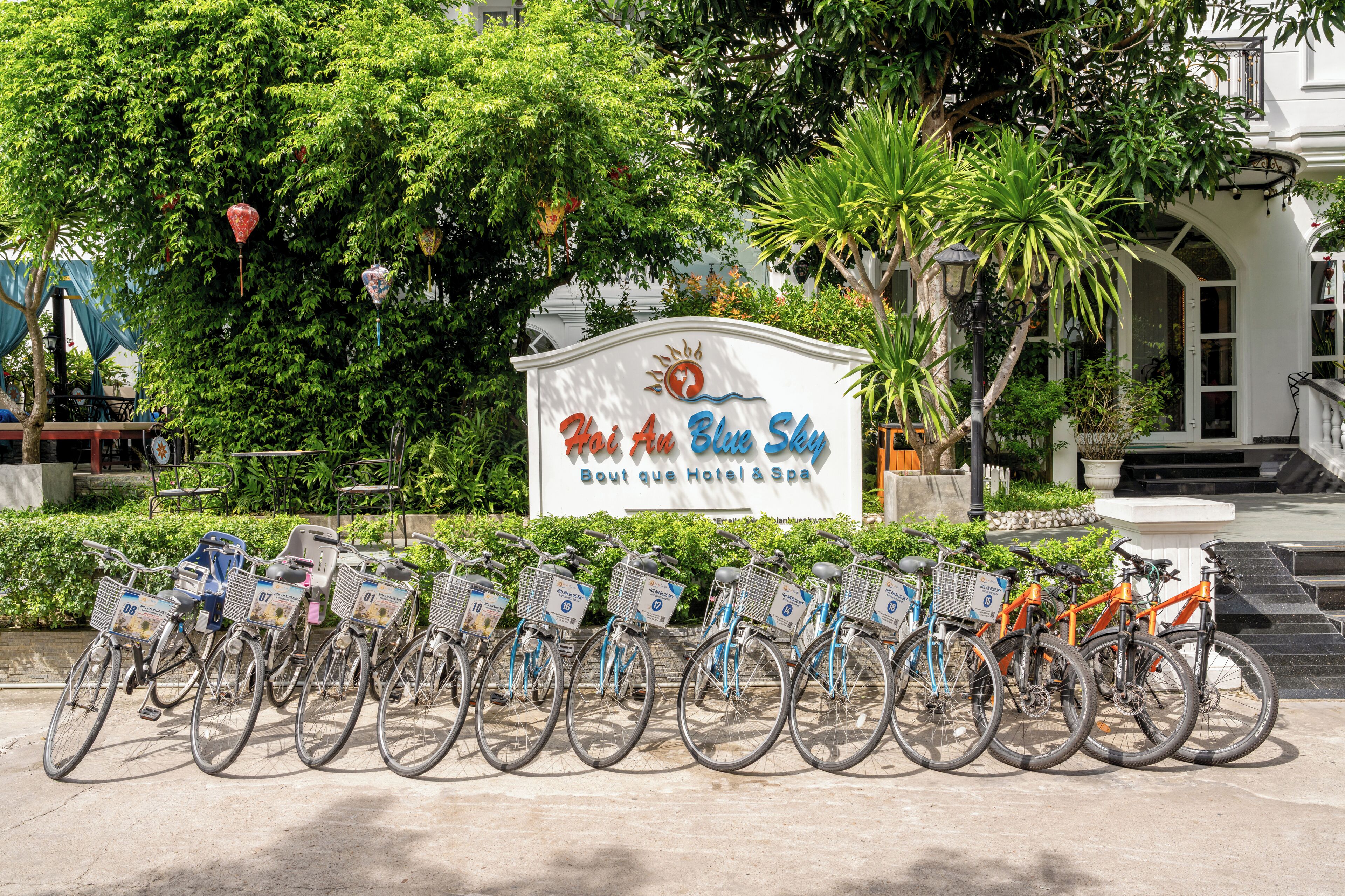 A row of bicycles parked in front of a hotel sign.