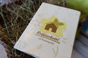 A brochure for 'Kräuterhotel zur Klostergrotte' with a house and leaf logo. - Kräuterhotel Garni zur Klostergrotte (Grammetal)
