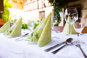 A table set with green napkins, silverware, and wine glasses. - Kräuterhotel Garni zur Klostergrotte (Grammetal)