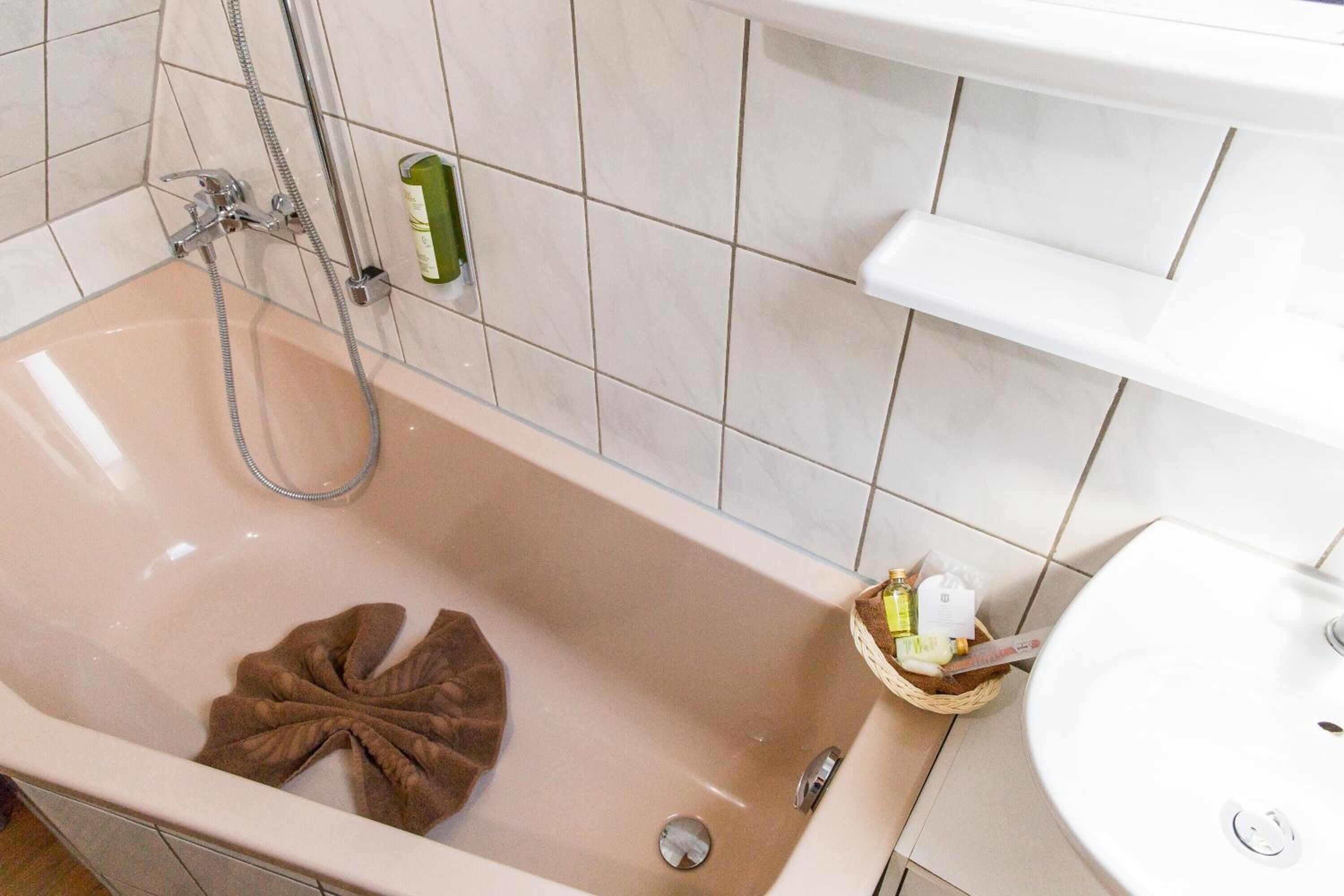 Un baño con bañera, ducha y lavamanos.
