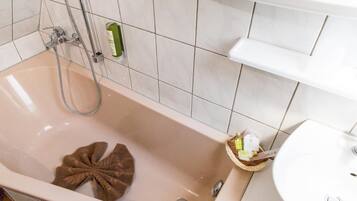 Un baño con bañera, ducha y lavamanos.