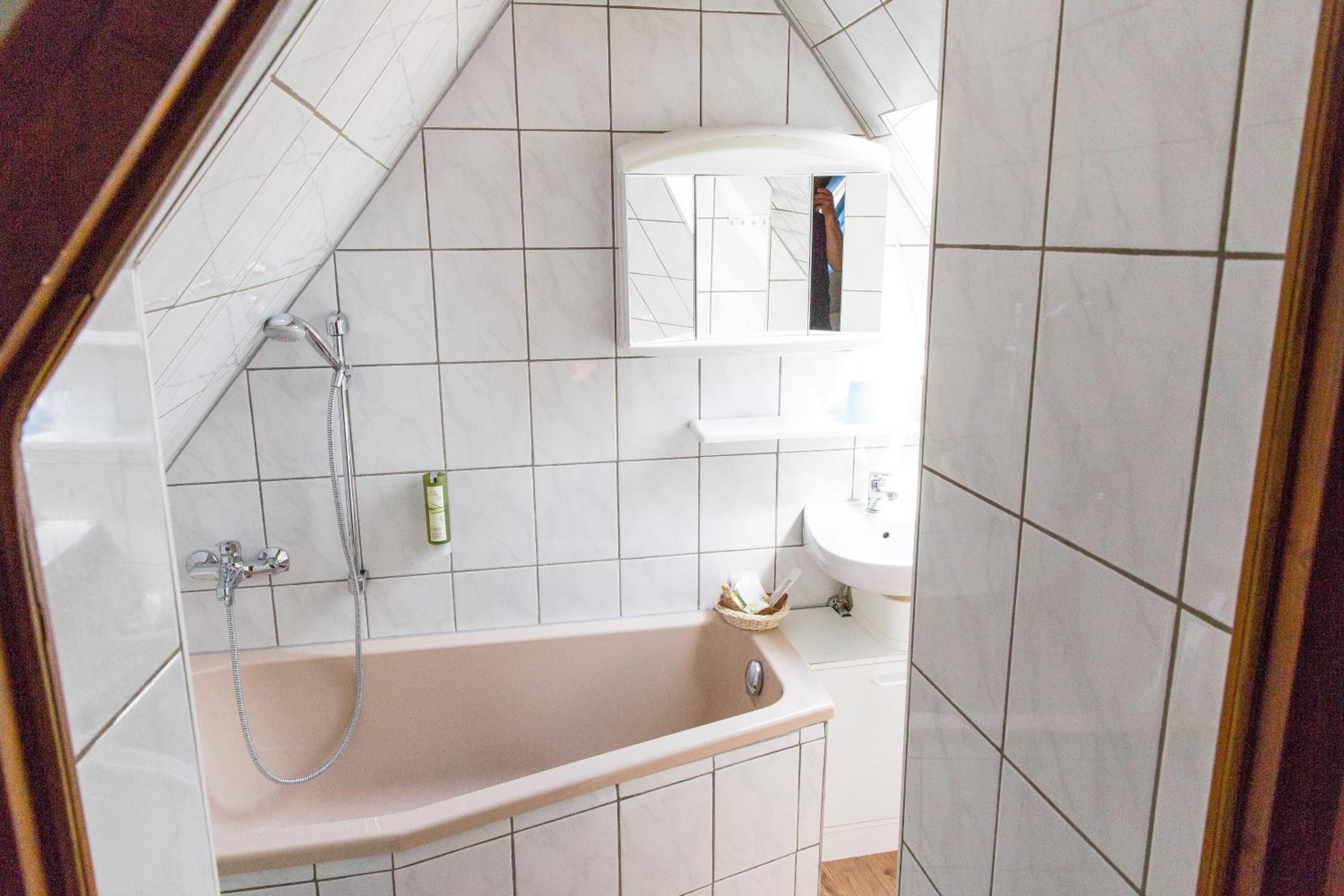 A bathroom with a bathtub, a shower, and a sink.