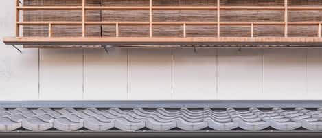 Un bâtiment à deux étages de style architectural japonais traditionnel, doté d’un balcon en bois et de portes coulissantes.