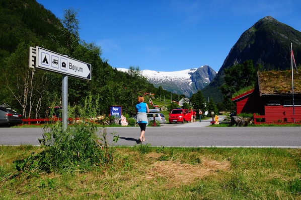 A road sign indicating a campsite with a mountain in the background.