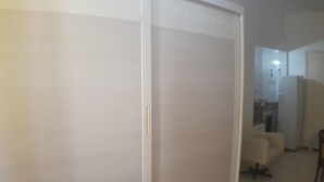 A room with a sliding door, a small kitchenette, and a seating area. - Gohouse - Laranjeiras 116 (Rio de Janeiro)