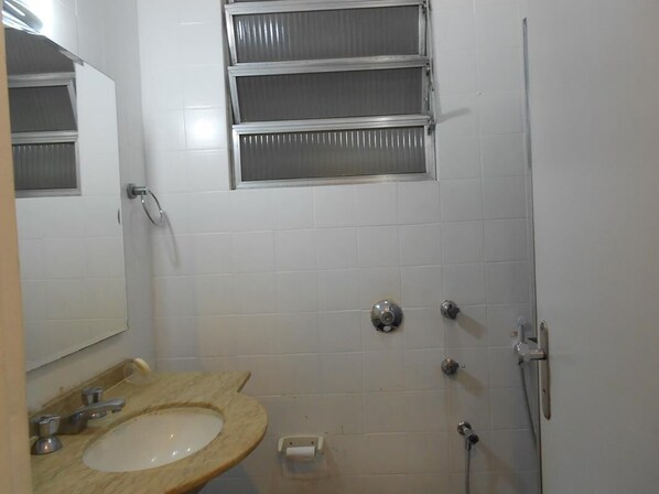 Un baño con lavamanos, espejo y ducha.