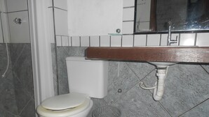 A bathroom with a toilet, a sink, and a shower area. - Gohouse - Suite Tonelero 03 (Rio de Janeiro)