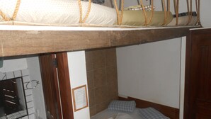 A bunk bed with a wooden headboard, a small bedside table, and a mirror. - Gohouse - Suite Tonelero 03 (Rio de Janeiro)